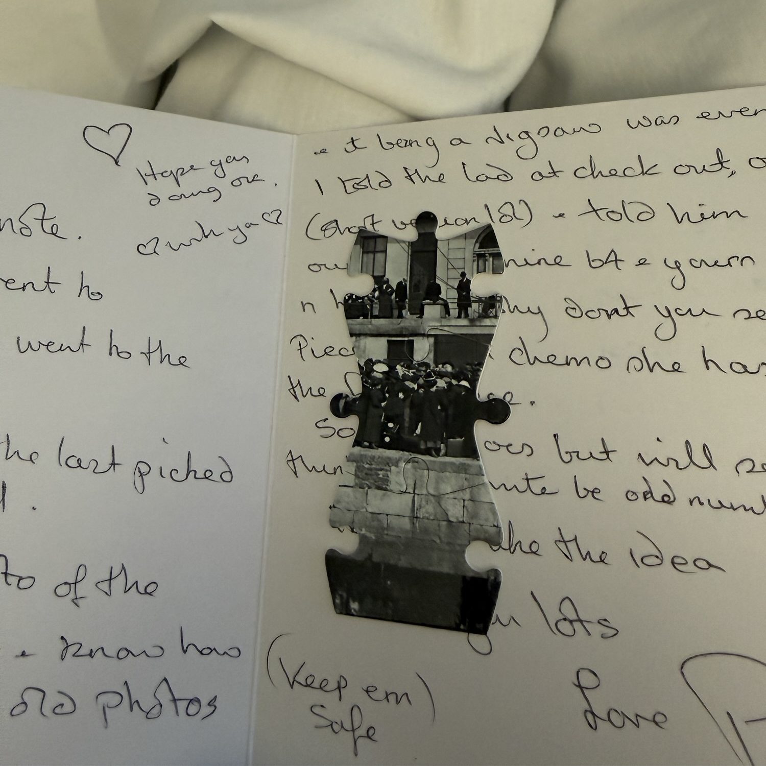 img_2035 Handwritten letter with visible text including a heart drawing and a photo puzzle piece showing a black and white image of people at a building